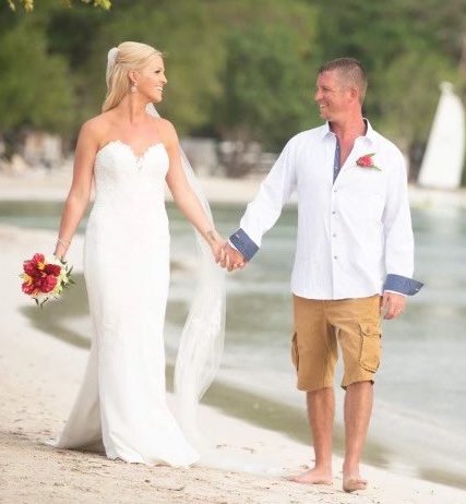 Bride and groom walking hand-in-hand on a tropical beach for a destination wedding